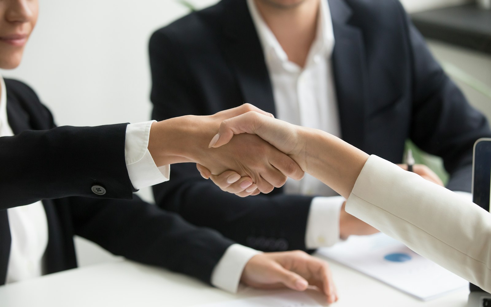 Business partners shaking hands to close a partnership agreement